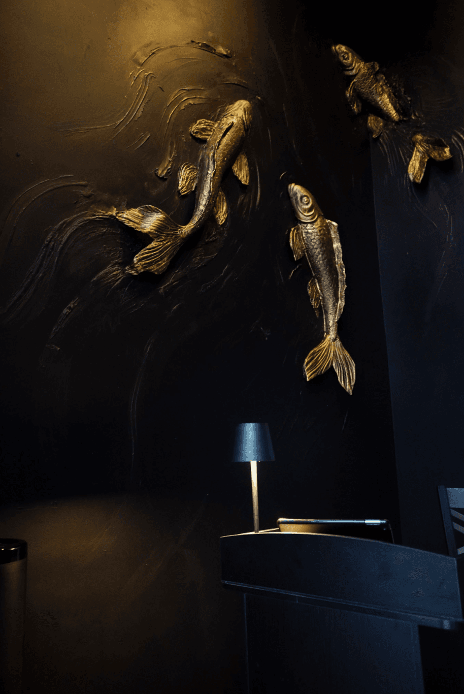 The intimate Tokyo Sushi Speakeasy dining room in warm, moody light.